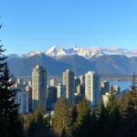 Cảnh đẹp Vancouver Canada với các tòa nhà cao tầng hiện đại và núi non hùng vĩ phía xa.